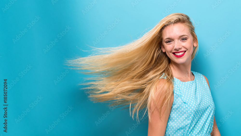 Young woman tossing her hair into the air Young woman tossing her hair into the air