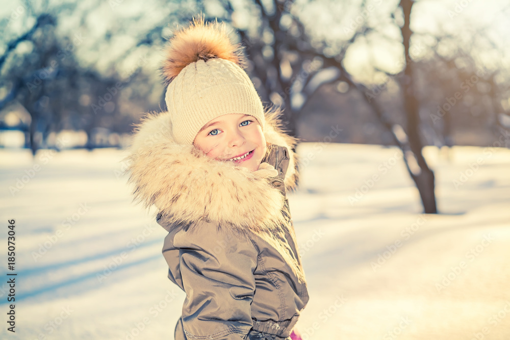 Portrait of little girl in sunny winter park Portrait of little girl in sunny winter park