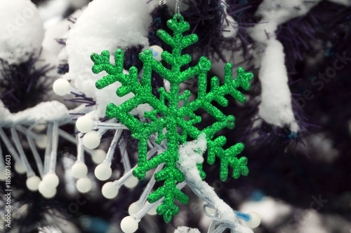 Christmas decoration with wooden snowflake on christmas tree and bokeh light background. Winter  Christmas  New Year decoration snowflake prepared from natural  solid wood.. Copy space. Closeup.