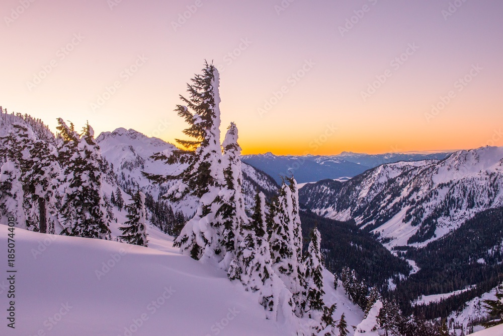 The snow covered Cascade Mountains and fresh powder at sunrise in winte