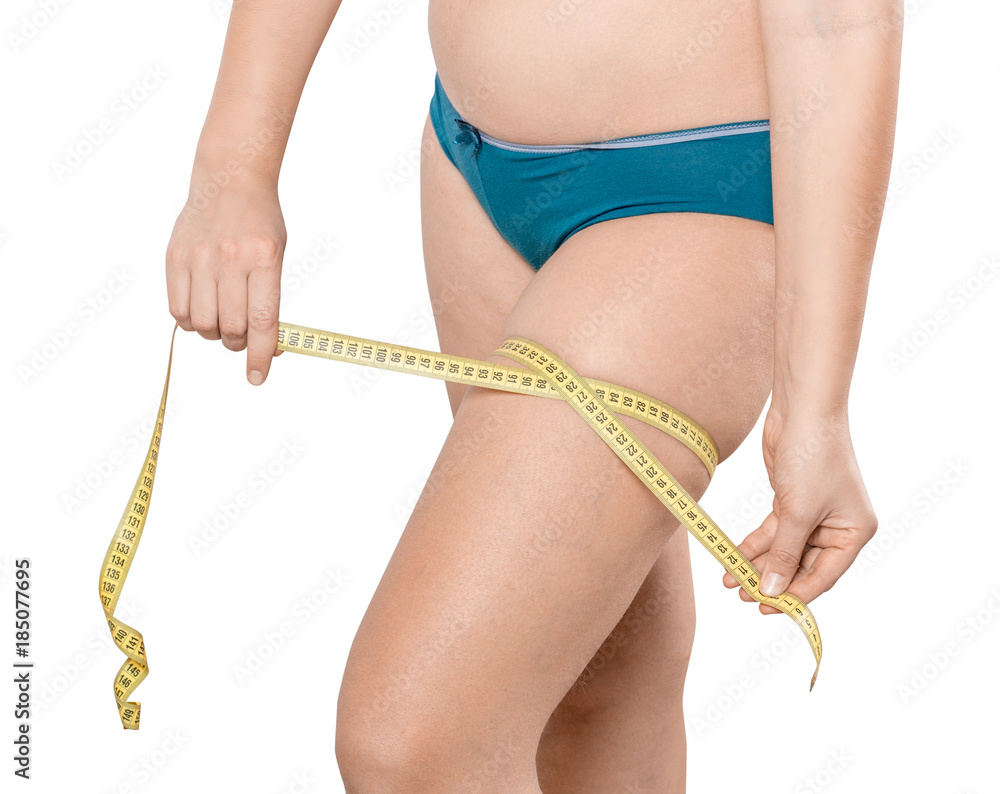 Fat girl with excess weight measures her hips with a measuring tape. Woman in lingerie on white isolated background Fat girl with excess weight measures her hips with a measuring tape. Woman in lingerie on white isolated background