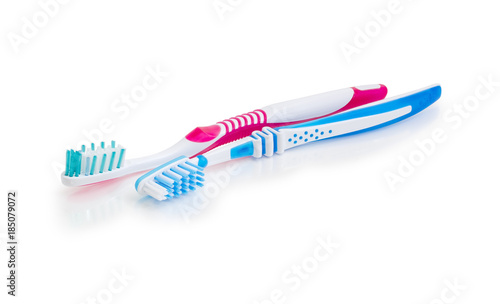 Two toothbrushes on a white matte surface closeup