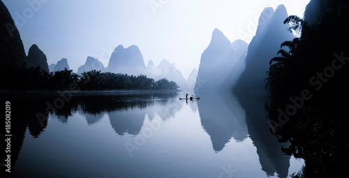 Person on rowboat in Li River at sunrise, China photo