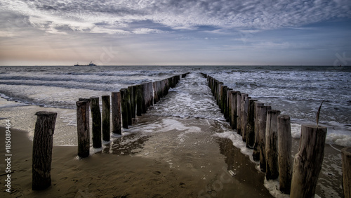 View on the wooden pier during sunny weather with clouds at the beach in Vlissingen, Zeeland, Holland, Netherlands