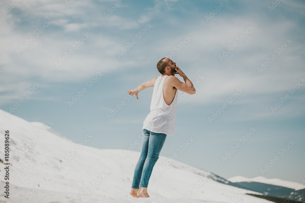 .Handsome young man dancing in the snow with bare feet. Taking joyful feelings, happy free and with dance. Lifestyle. .Handsome young man dancing in the snow with bare feet. Taking joyful feelings, happy free and with dance. Lifestyle.
