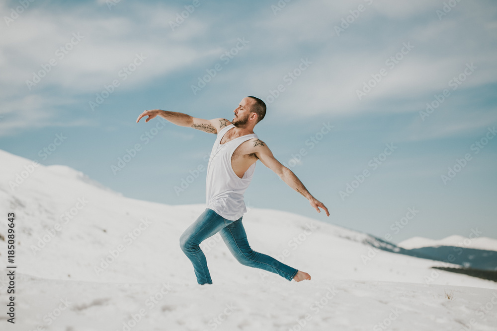.Handsome young man dancing in the snow with bare feet. Taking joyful feelings, happy free and with dance. Lifestyle. .Handsome young man dancing in the snow with bare feet. Taking joyful feelings, happy free and with dance. Lifestyle.