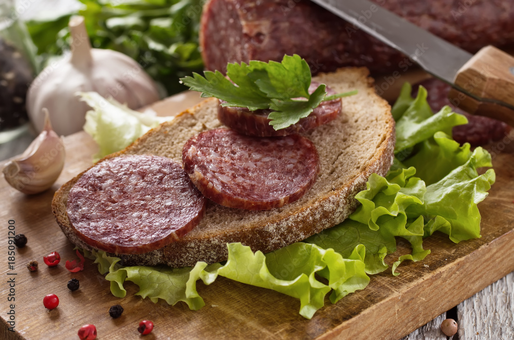salami and bread on a wooden board salami and bread on a wooden board