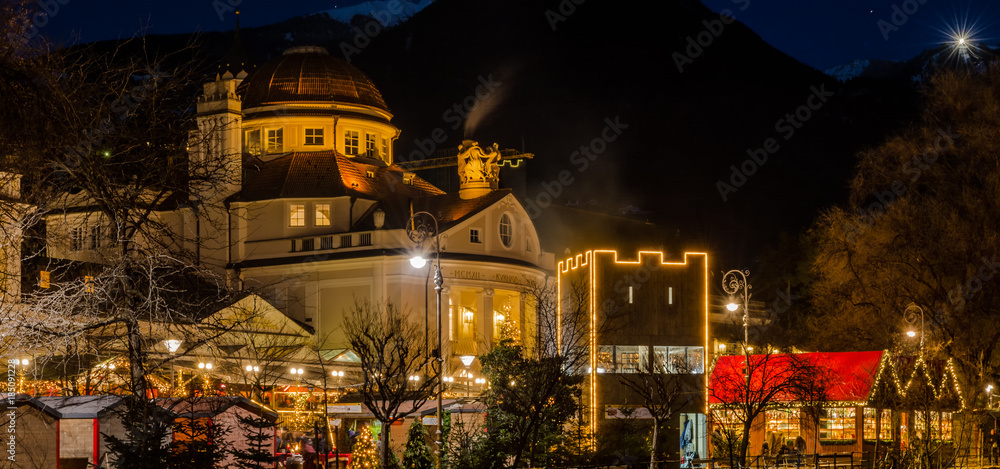 Meran Merano in South Tyrol, Italy, during the Christmas with christmans market by night . Beautiful light and great atmosphere - obrazy, fototapety, plakaty 