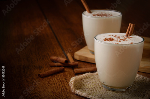 Eggnog houmemade with cinnamon and kakao for Christmas and winter holidays or wooden broun backgrounds