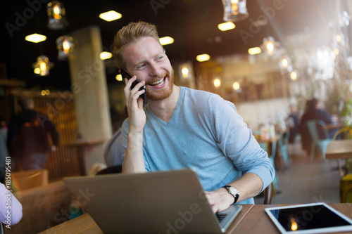 Young man having phone call in coffee shop