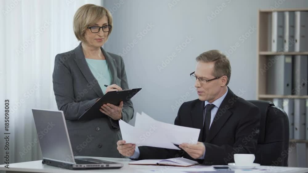 Satisfied male boss happy with correct report by woman accountant, good done job Satisfied male boss happy with correct report by woman accountant, good done job