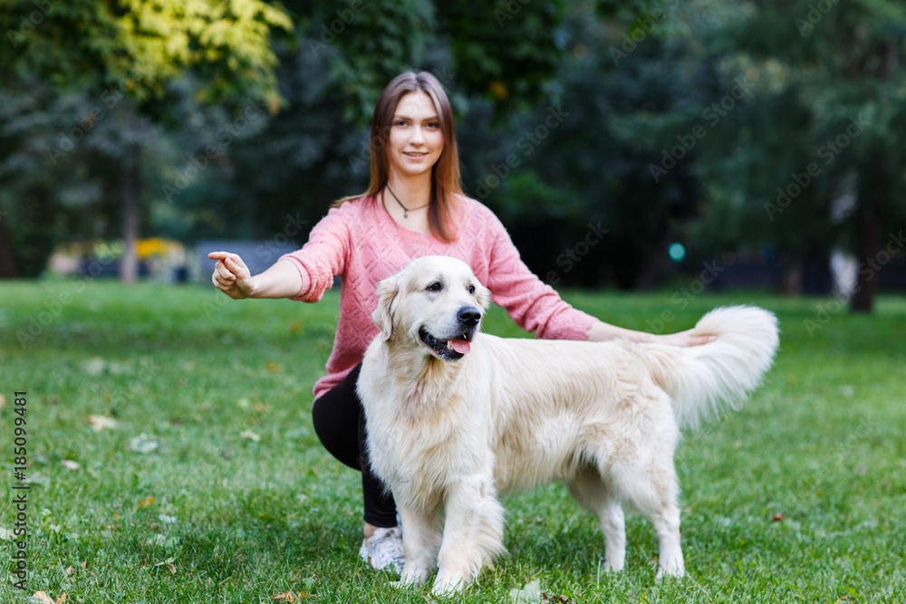 Image of brunette with dog on green lawn Image of brunette with dog on green lawn
