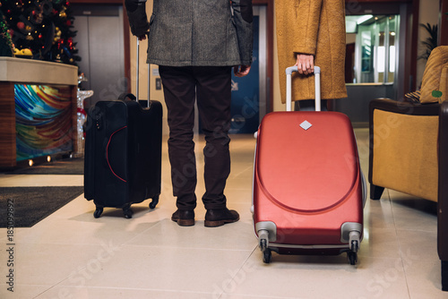 cropped shot of couple with suitcases walking at hotel hallway © LIGHTFIELD STUDIOS