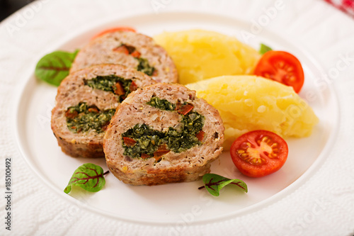 Roll of turkey minced meat with spinach and red sweet pepper with garnish of mashed potatoes