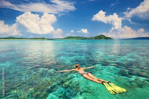 Kobieta z rurką w czystych wodach tropikalnych na tle egzotycznych wysp.