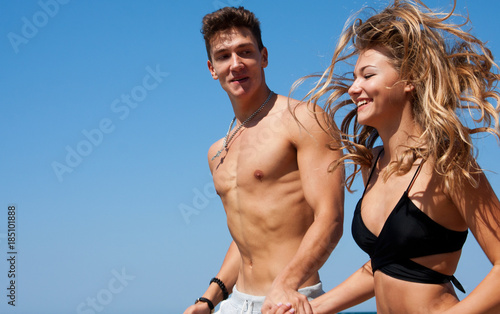 Beautiful couple running on the beach