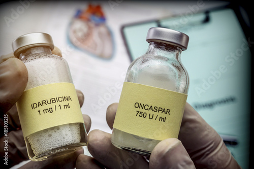 Doctor holds two vials of idarubicina and Oncaspar to inject, medicine used in acute lymphatic leukemia disease photo