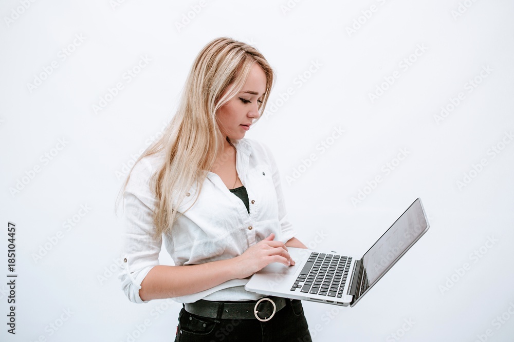 Young girl holding a laptop standing on a white background Young girl holding a laptop standing on a white background