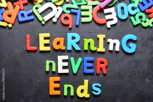 Learning never ends words written on chalkboard with colorful plastic letters