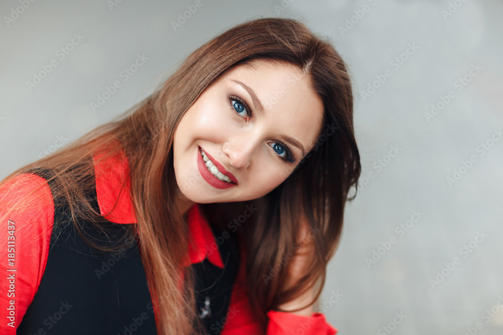 close-up Portrait of young smiling woman looking at camera, smiling. Attractive girl with long hair sitting on steps an throwing up her long hairs. close-up Portrait of young smiling woman looking at camera, smiling. Attractive girl with long hair sitting on steps an throwing up her long hairs.