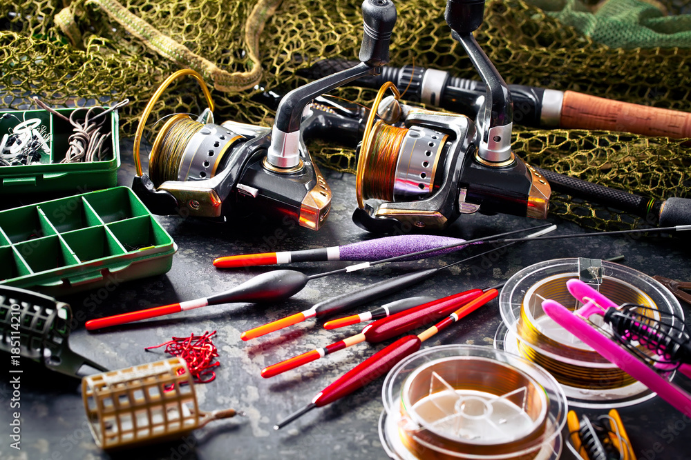 Fishing rods and spinnings in the composition with accessories for fishing on the old background on the table Fishing rods and spinnings in the composition with accessories for fishing on the old background on the table