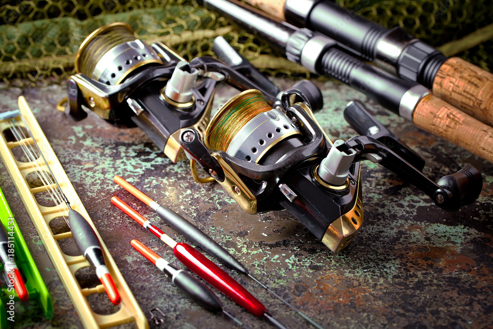 Fishing rods and spinnings in the composition with accessories for fishing on the old background on the table Fishing rods and spinnings in the composition with accessories for fishing on the old background on the table