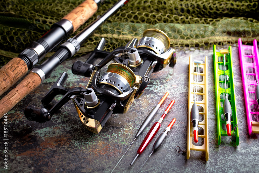 Fishing rods and spinnings in the composition with accessories for fishing on the old background on the table Fishing rods and spinnings in the composition with accessories for fishing on the old background on the table