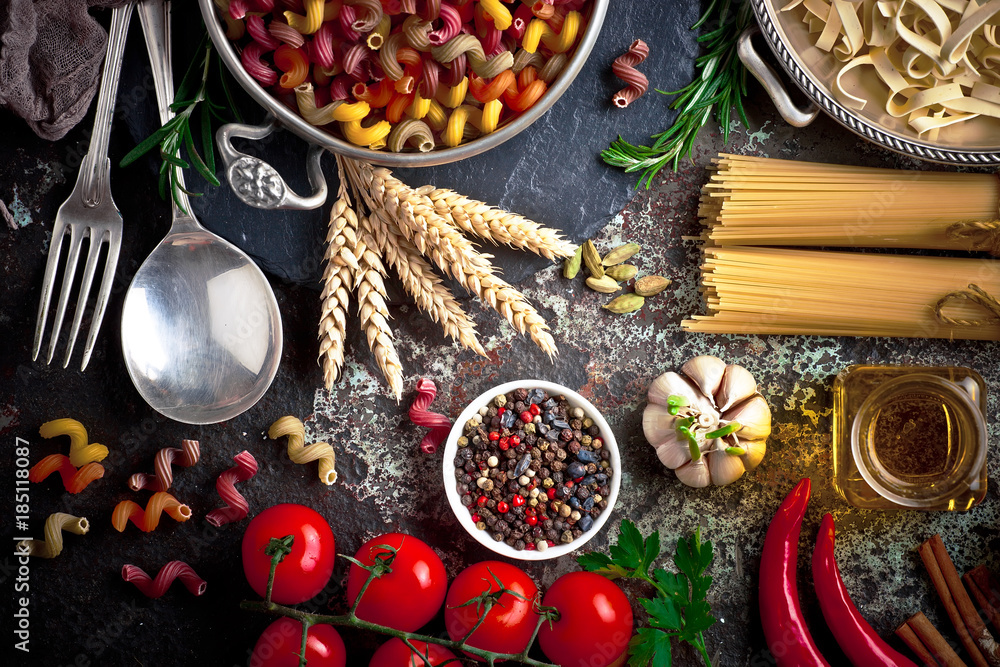 Raw pasta in the composition on the table with items for cooking Raw pasta in the composition on the table with items for cooking