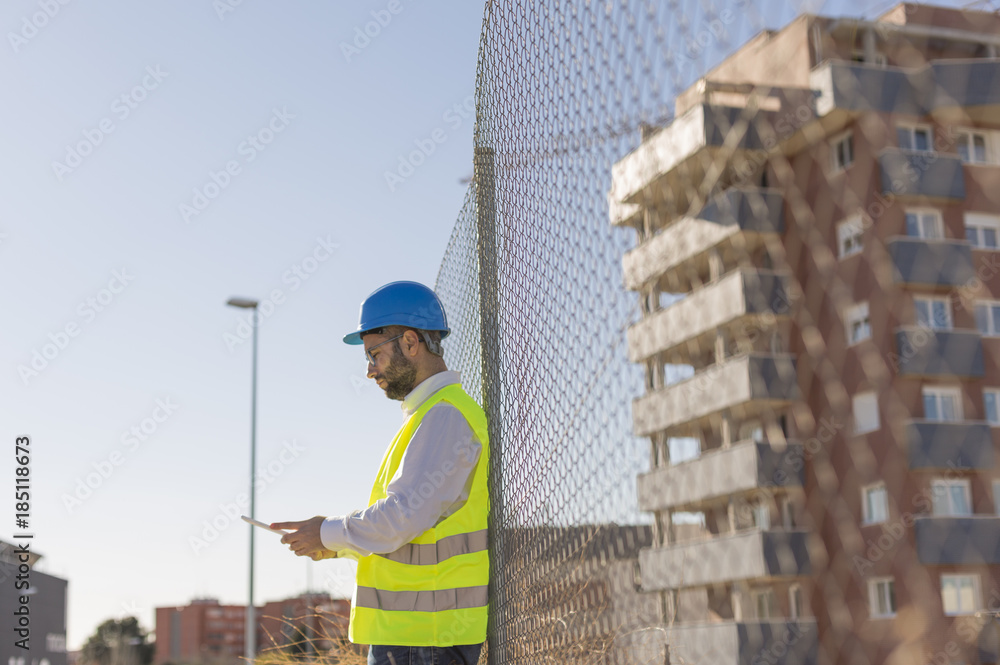 Architect or Engineer using tablet on the Construction Site. hol Architect or Engineer using tablet on the Construction Site. hol