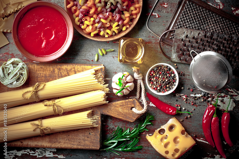Raw pasta in the composition on the table with items for cooking Raw pasta in the composition on the table with items for cooking