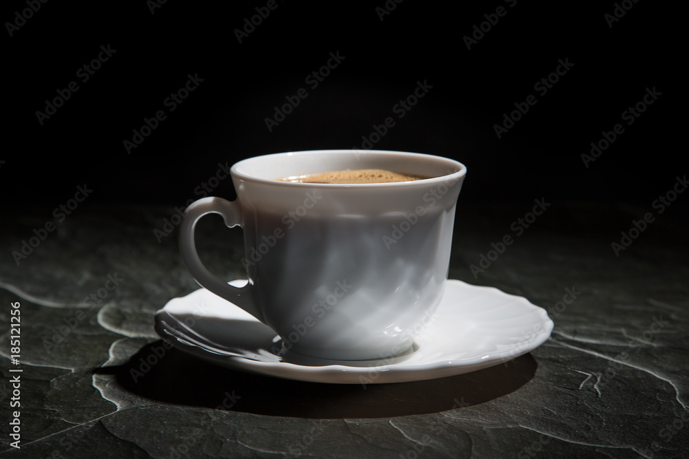 white cup of coffee and a saucer on a black background white cup of coffee and a saucer on a black background