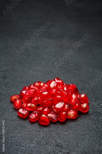 Pomegranate seeds close-up on dark concrete background