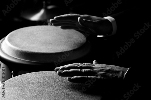 Canvas Print Hands of a musician playing on bongs closeup in black and white tones