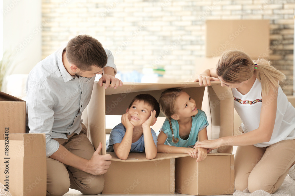 Parents playing with children while unpacking things in new flat Parents playing with children while unpacking things in new flat