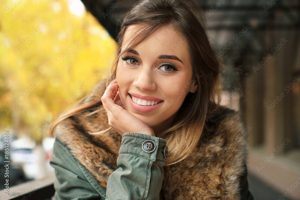 Attractive smiling woman in jacket with fur collar in open air cafe Attractive smiling woman in jacket with fur collar in open air cafe