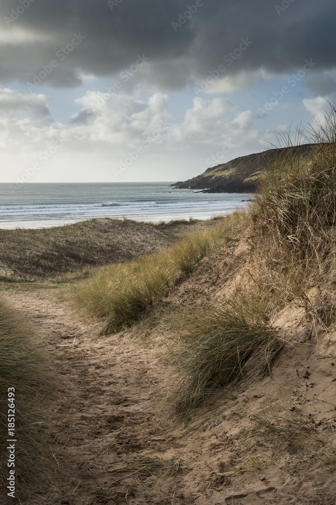 Beautiful landscape image of Freshwater West beach with sand dunes on Pembrokeshire Coast in Wales