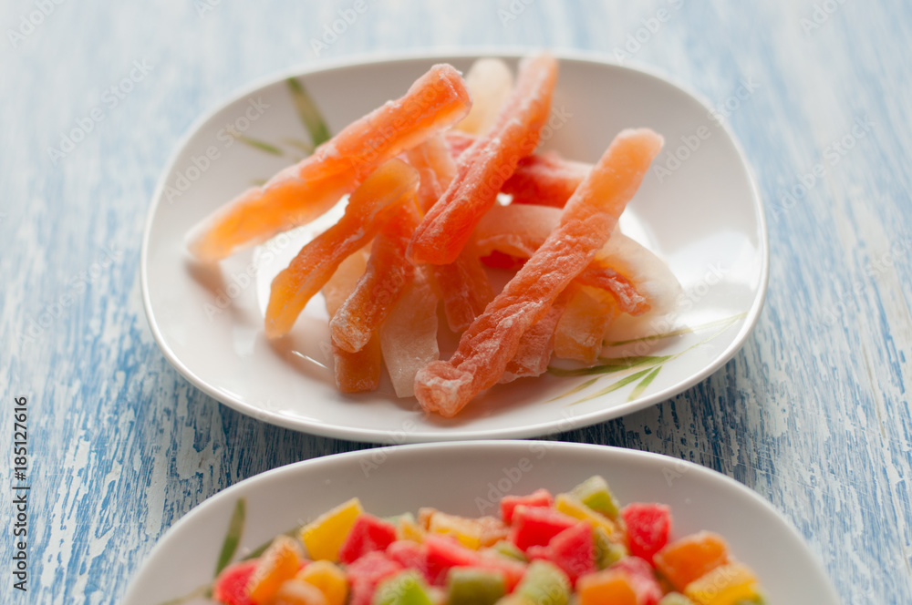 Candied papaya in a white plate on a wooden background Candied papaya in a white plate on a wooden background