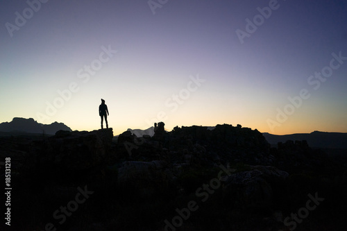Silhouette of a young female hiker at sunset in the mountains while travelling through South Africa on holiday