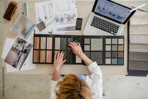 Overhead photo of woman interior designer working with material palette at her office. photo
