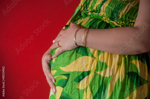 détail ventre de femme enceinte dans une jolie robe fleurie