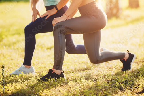 Fitness. Girls group of friends train in park with yoga and fitness