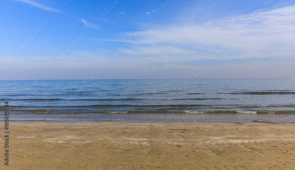 Empty sandy beach. Blue sky and sea at evening. Closeup view.