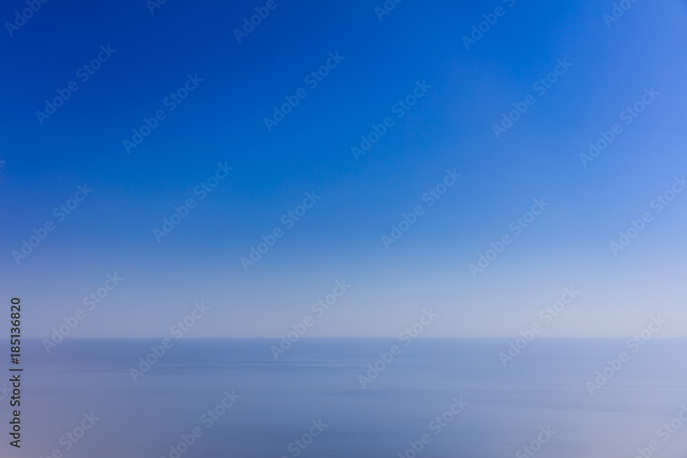 Calm sea and blue sky backdrop. Blurred view. Calm sea and blue sky backdrop. Blurred view.