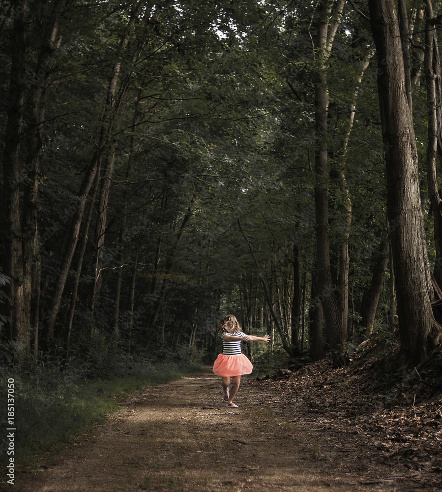 Girl dancing on dirt road amidst forest Girl dancing on dirt road amidst forest