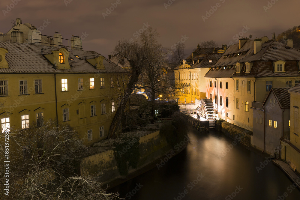 Night romantic snowy Prague Flourmill above Certovka, Czech republic