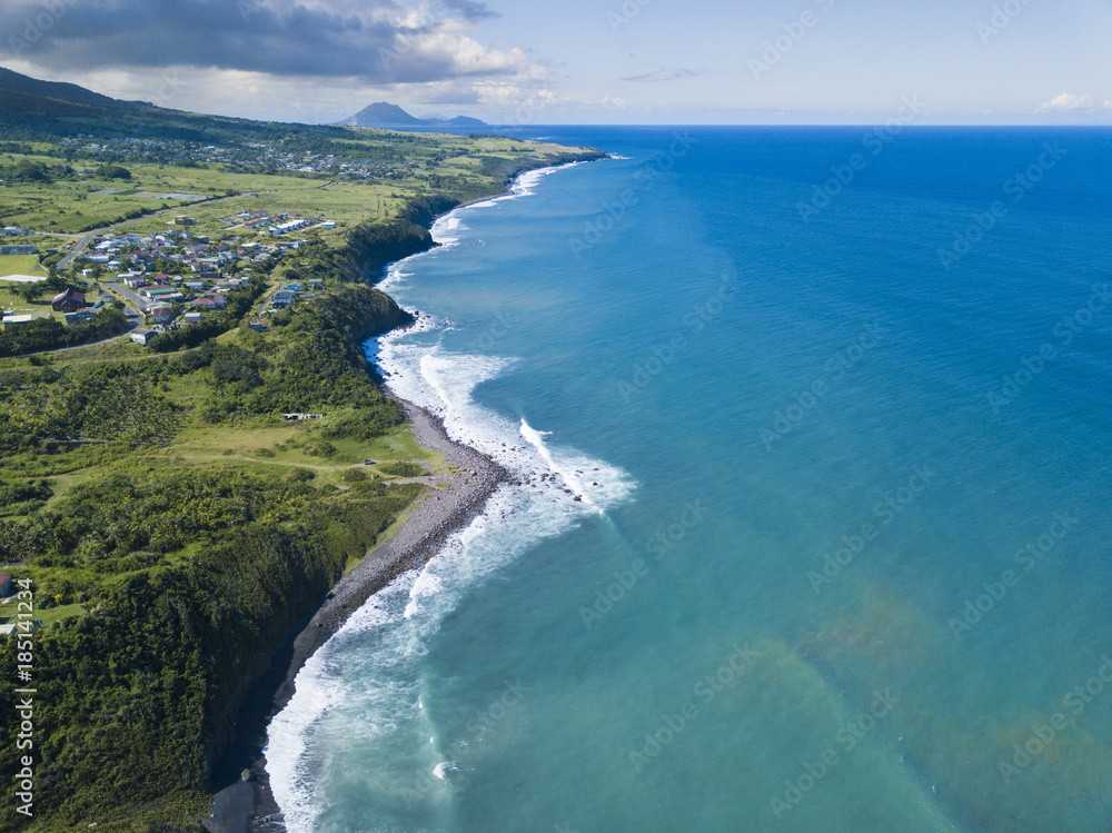 Aerial view of Black Rocks Beach on St Kitts with the island of Nevis in the background.