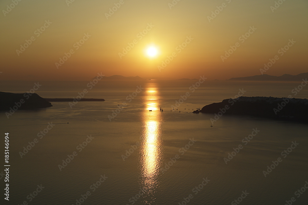 Sunset on Santorini island with some sailboats, Greece