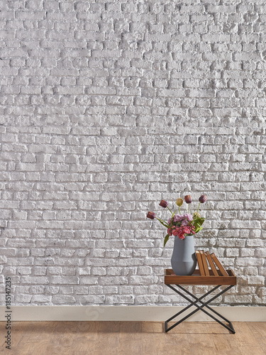 Fototapeta szary wazon z kwiatami na tle ściany z cegieł