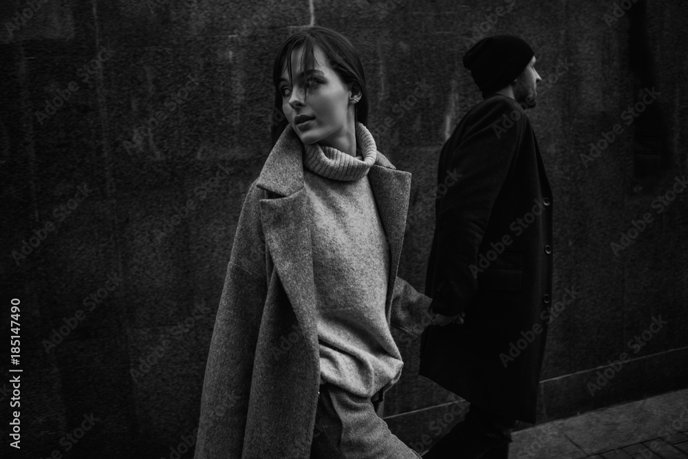 Naklejka premium Beautiful couple in stylish clothes in gray tones, city