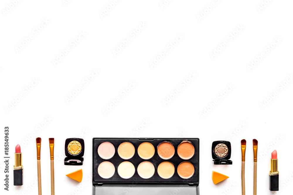 Professional bulk cosmetics pattern. Eyeshadows, rouge, brushes on white background top view copyspace Professional bulk cosmetics pattern. Eyeshadows, rouge, brushes on white background top view copyspace